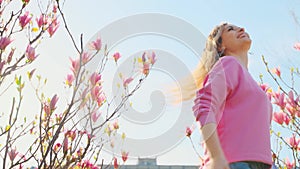 Portrait young beautiful happy woman dancing whirls joyful girl enjoys Sunny day spring nature botany garden magnolia