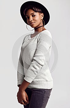 Young beautiful hipster black girl in white sweater and hat