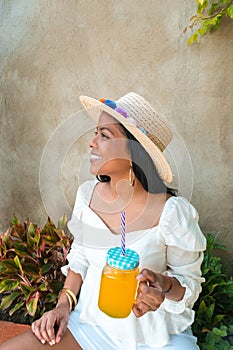 Portrait of a young beautiful Hispanic girl holding a drink