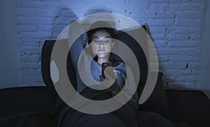 Portrait of young beautiful latin woman using mobile phone late night sleepless lying in bed in the dark in smartphone and interne