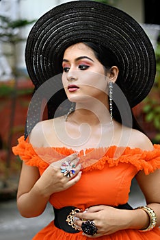 Portrait of young beautiful modern Indian woman wearing western outfit with black straw hat