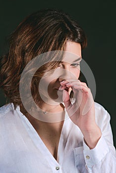 Portrait of young, beautiful sad actress with short brown hair in white shirt and blue pants