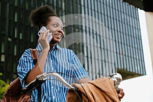 Portrait of young beautiful smiling african woman talking phone