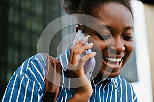 Portrait of young beautiful smiling african woman talking phone