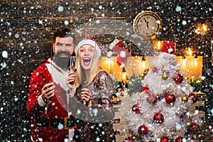 Portrait of a young beautiful smiling couple in home Christmas mood. Make funny face. Couple in love. Drunk Girls