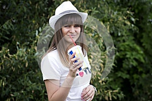 Portrait of young beautiful smiling girl in hat with cocktail glass with straw in hand in outdoor. Summer mood