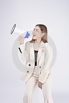 Portrait of young beautiful smiling woman in suit using megaphone to announce over isolated white background studio
