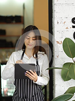 Young beautiful waitress taking an order on digital tablet in restaurant