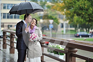 Portrait of young beautiful wedding couple in a rainy day