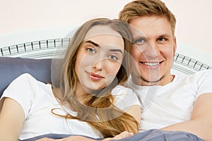 Portrait young beautiful white couple lying together in bed - Teen loving family