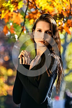 Portrait of young beautiful woman in autumn park.