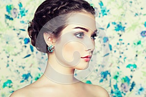 Portrait of young beautiful woman on a background of flowers