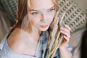 Portrait of a young beautiful woman in bed in the morning at home. Blonde girl in scandinavian interior. Good morning. Lifestyle.