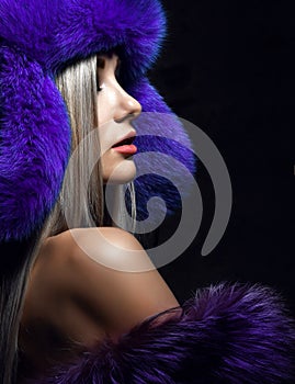 Portrait of young beautiful woman in blue purple fashion arctic fox winter fur ear flap hat