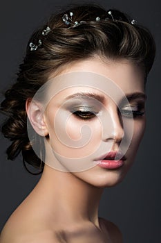 Portrait of young beautiful woman with bridal makeup and coiffure photo