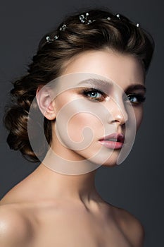 Portrait of young beautiful woman with bridal makeup and coiffure