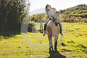 A Portrait of young beautiful woman with brown horse outdoors