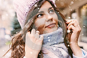 Portrait of young beautiful woman in coat and hat enjoing first snow