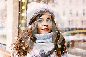 Portrait of young beautiful woman in coat and hat enjoing first snow