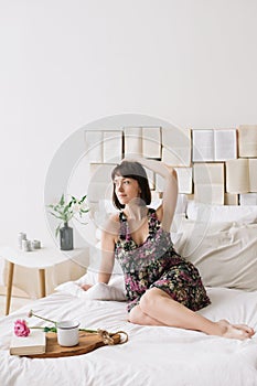 Portrait of a young beautiful woman in bed at home. Beautiful young brunette in the bedroom. Good morning. Lifestyle.