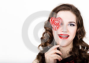 Portrait of young beautiful woman with dental braces holding sugarplum