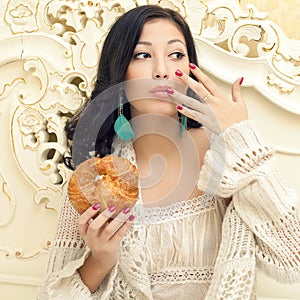 Portrait of young beautiful woman eating her croissant