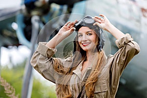 Portrait of a young beautiful woman in a helmet and pilot`s suit