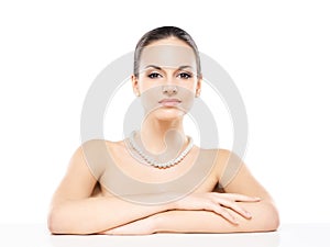 Portrait of young, beautiful woman in jewels on white