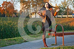 Portrait of the young beautiful woman in leather boots in the p