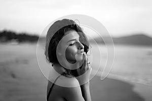 Portrait of a young beautiful woman with long curly hair at the seaside