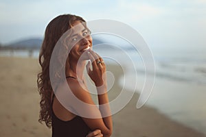 Portrait of a young beautiful woman with long curly hair at the seaside