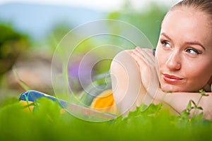 Portrait of young beautiful woman lying in grass