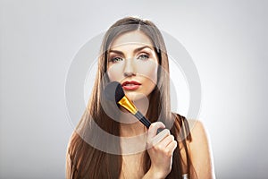 Portrait of young beautiful woman. Make up brush. Isolated