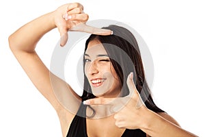 Portrait of young beautiful woman making frame with her hands