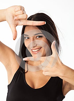 Portrait of young beautiful woman making frame with her hands