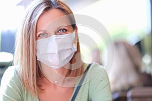 Portrait of young beautiful woman in medical protective mask photo