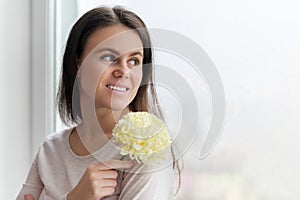 Portrait of young beautiful woman with natural makeup long hair with large flower