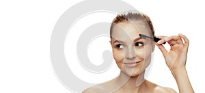 Portrait of young beautiful woman with natural makeup using brow mascara isolated over white studio background. Flyer