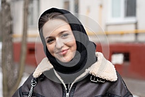 portrait of a young beautiful woman outside in a black headscarf in the city