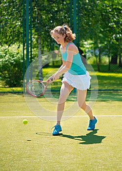 Portrait of young beautiful woman playing tennis