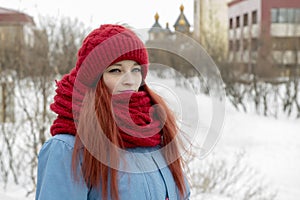 Portrait of young beautiful woman in red hat and red comforter