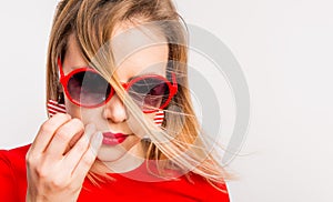 Portrait of a young beautiful woman with red sunglasses in studio.