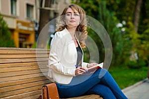 Portrait of young beautiful woman relaxing on the bench