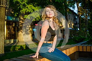 Portrait of young beautiful woman relaxing on the bench