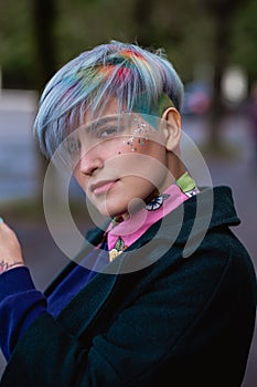 Portrait of a young beautiful woman with a short haircut and dyed hair. Grey main color and yellow, green, blue and red