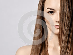 Portrait of young beautiful woman with silky long straight hair and hazel eyes looking at camera