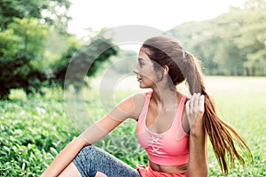Portrait of young beautiful woman sitting after break workout at park,Happy and smiling,Relaxing time
