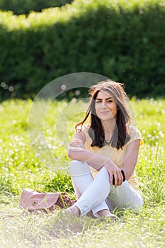 Portrait of young beautiful woman in summer city park.