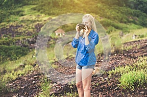 Portrait of young beautiful woman taking a photo while standing at outdoor,Travel nature concept