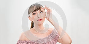 Portrait of young beautiful woman touching her face, isolated on white background